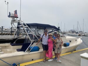 Three people standing on the side of a boat.